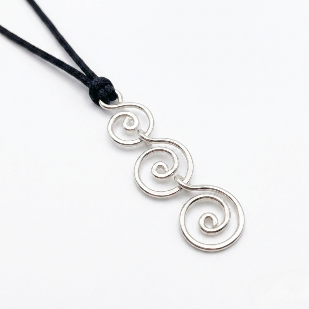 Silver spiral pendant on a black cord against a white background