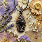 Copper wire-wrapped pendant on a bed of dried flowers