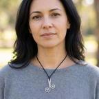 Woman wearing a necklace with a unique pendant outdoors