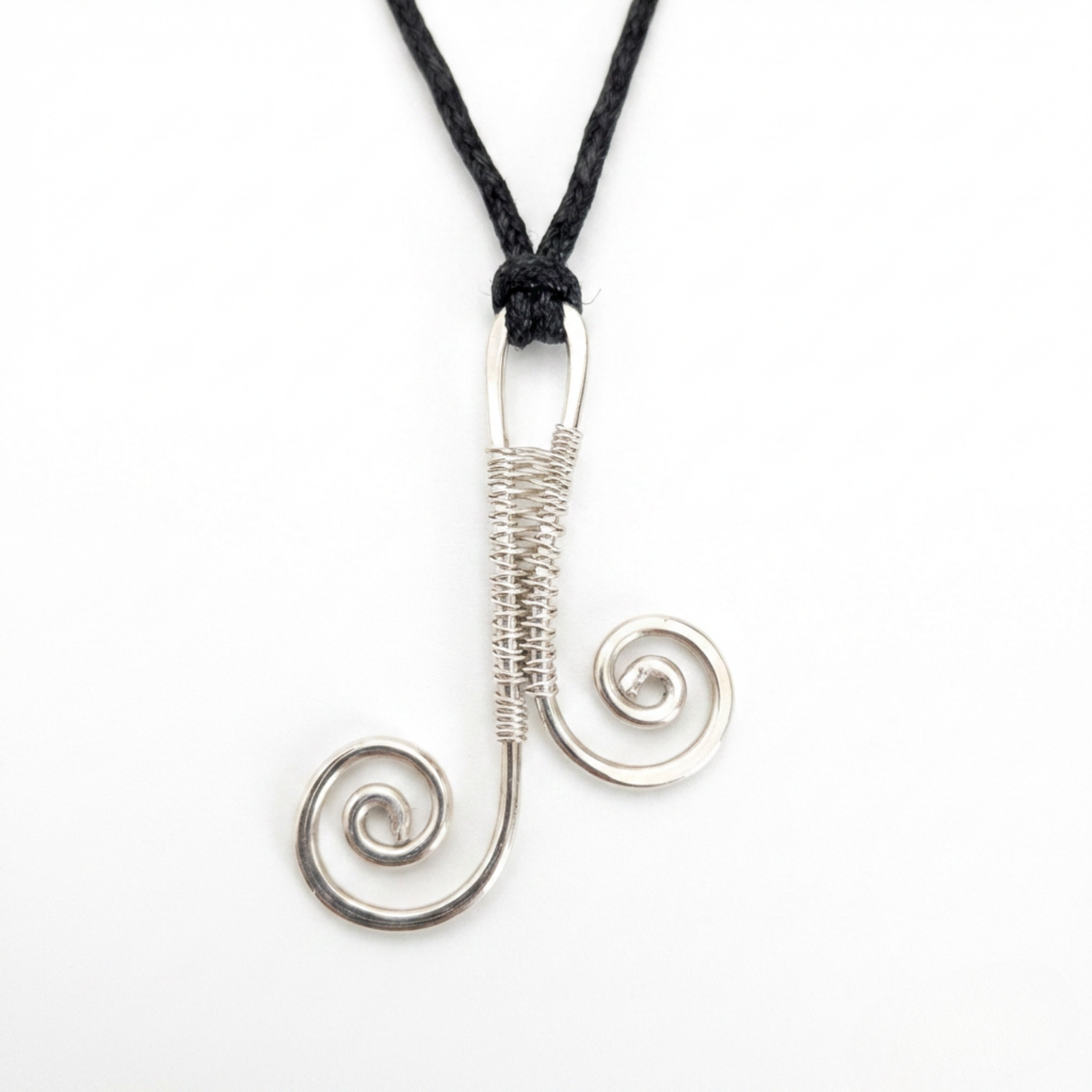 Silver spiral pendant on a black cord against a white background