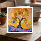 Colourful abstract tree design on a greeting card placed on a wooden surface with a cup and plant in the background.