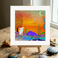 Colourful abstract artwork of a Moon Gazing Hare and Glastonbury Tor  on a wooden easel with decorative stones on a wooden surface.