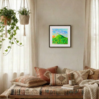 Cozy living room with patterned pillows, a blanket, and a framed painting on the wall.