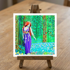 Colourful artwork of a woman with red hair on a wooden easel