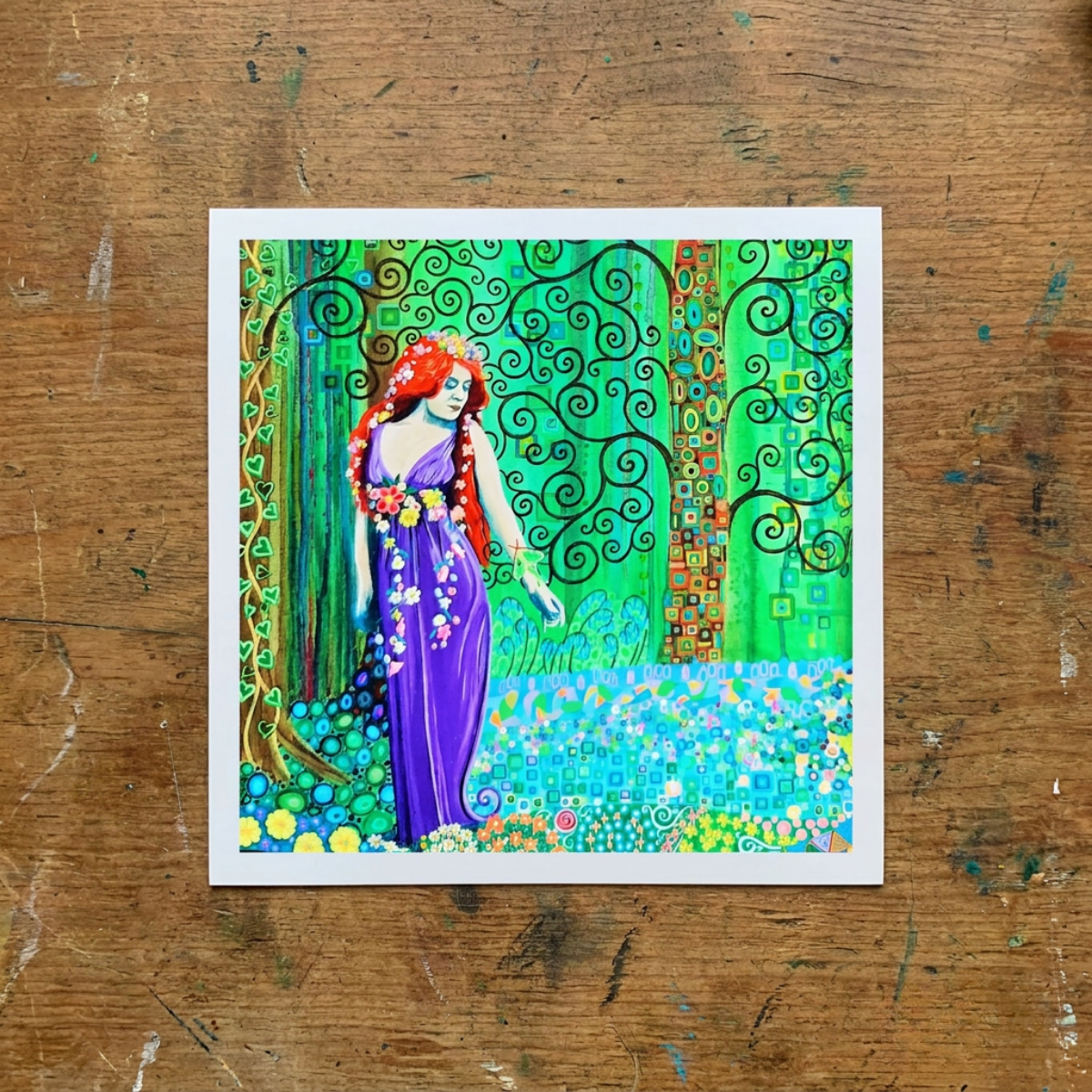 Colourful artwork of a woman in a purple dress with floral elements on a wooden surface