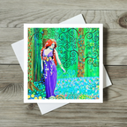 Colourful greeting card with a stylized woman and tree design on a wooden surface