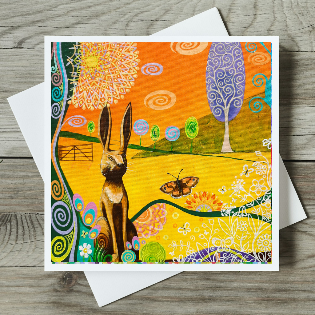 Colourful card with a hare and butterfly design on a wooden surface
