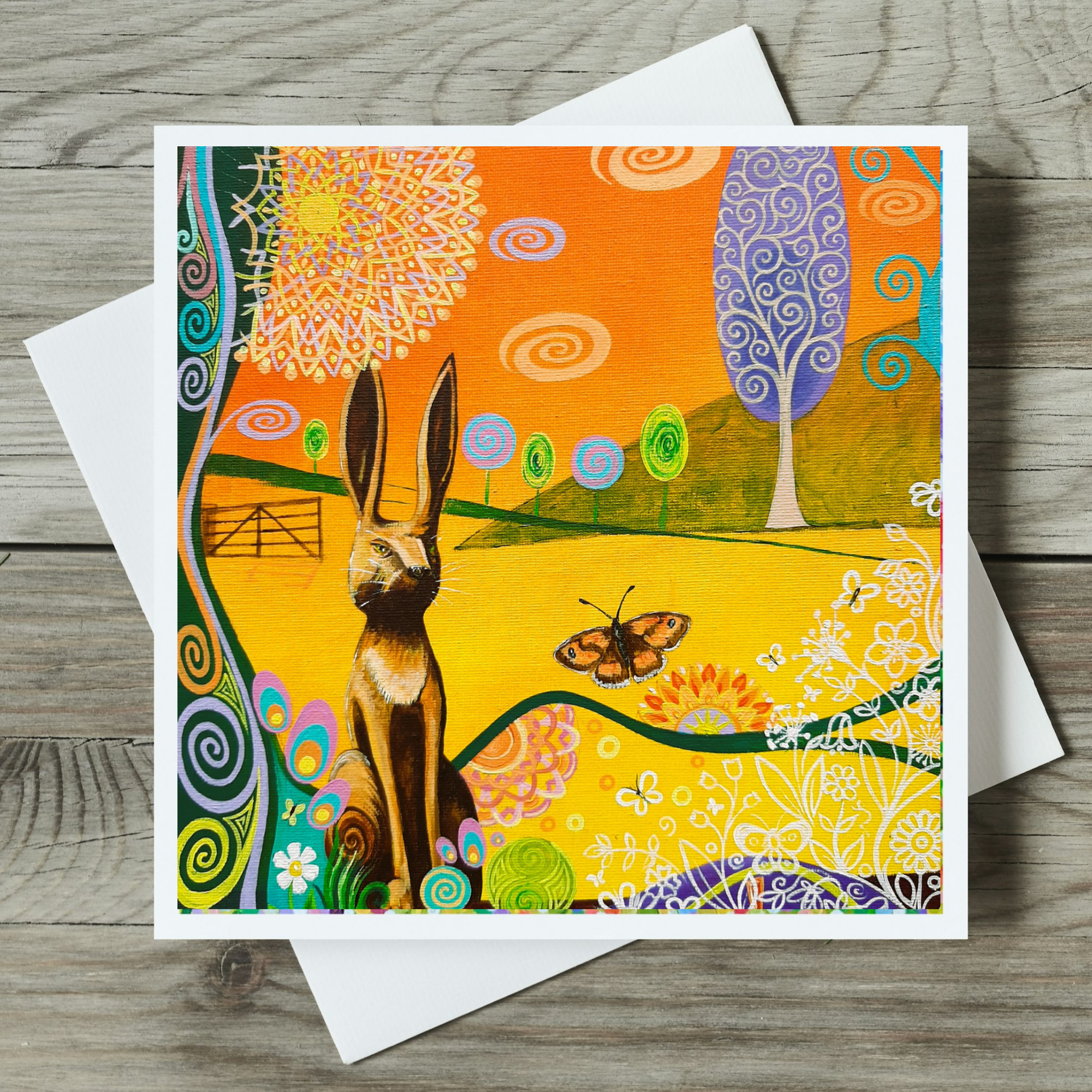 Colourful card with a hare and butterfly design on a wooden surface