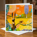 Colourful greeting card with a hare and butterfly design on a wooden surface