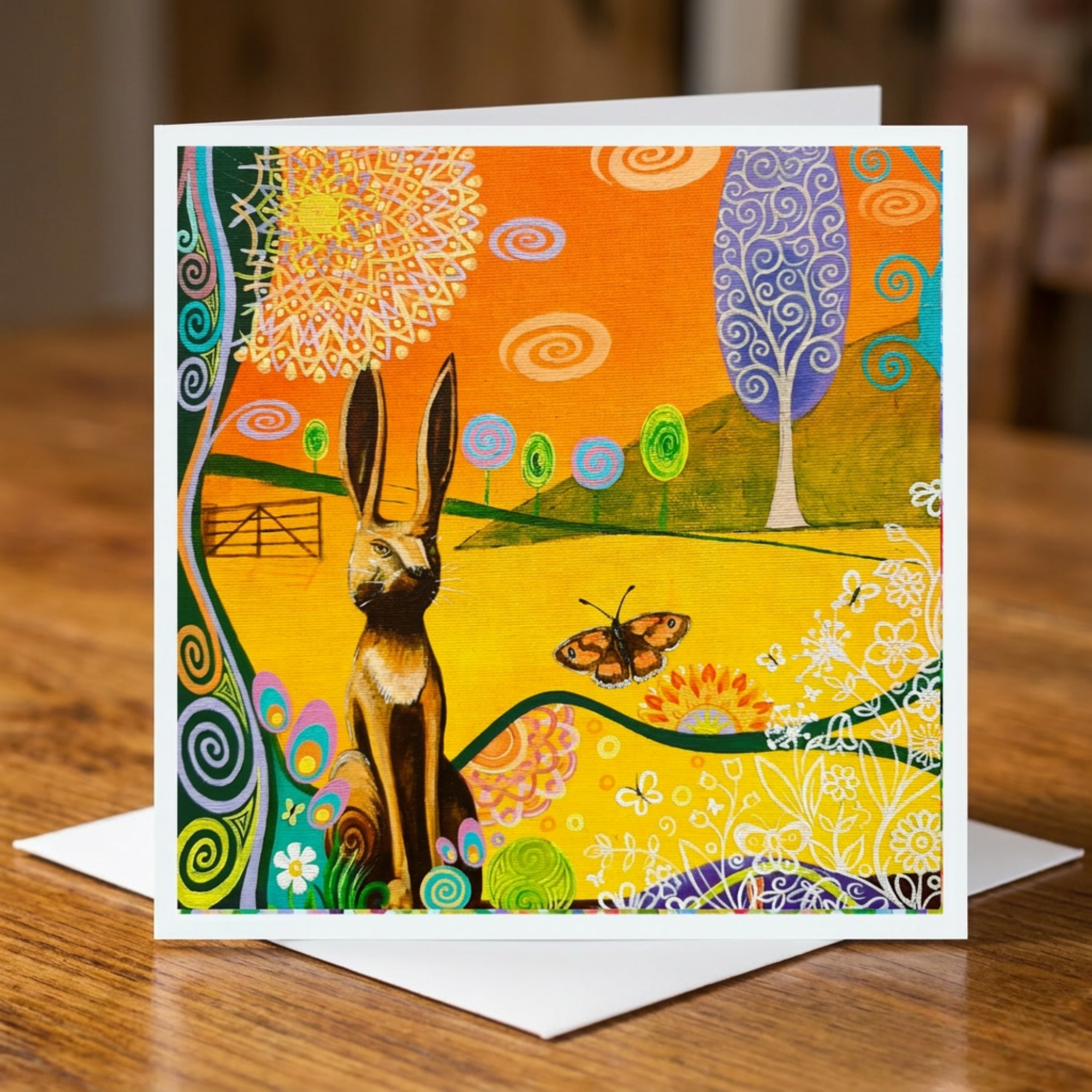 Colourful greeting card with a hare and butterfly design on a wooden surface