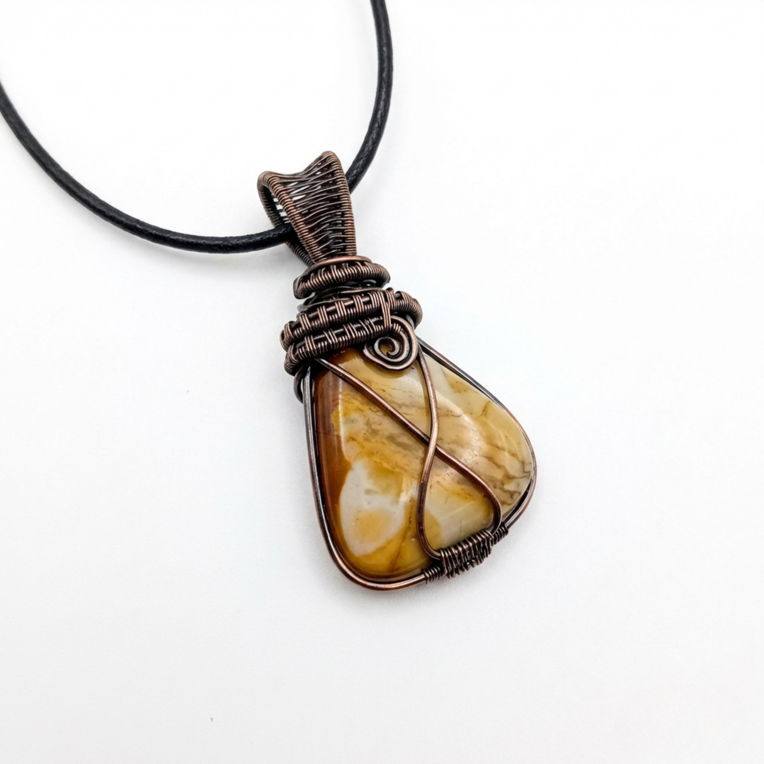 Necklace with a stone pendant wrapped in copper wire on a white background