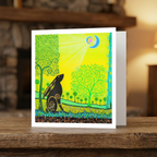 Colourful greeting card with a stylized tree and moon gazing hare design on a wooden surface.