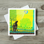 Colourful greeting card with a rabbit and trees on a wooden surface