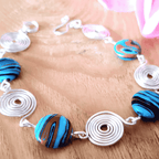 Necklace with spiral and round beads on a wooden surface