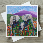 Colorful card with elephants and floral patterns on a wooden surface