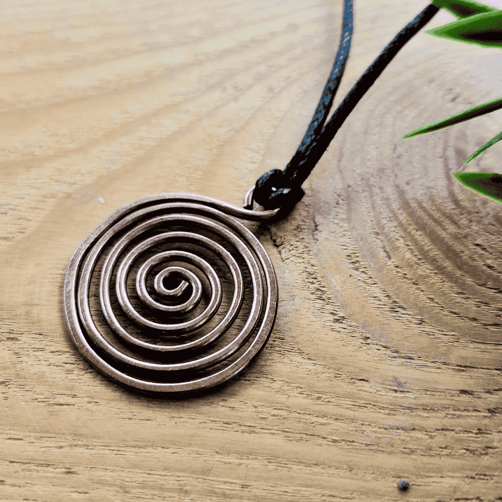 Copper spiral pendant on a wooden surface