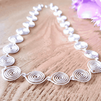 Close up view showing the tead drop spirals n this silver spiral necklace