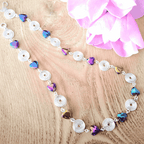 Necklace with heart-shaped beads on a wooden surface with pink flowers