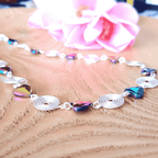 Necklace with colourful heart-shaped hematite beads and silver spirals on a wooden surface