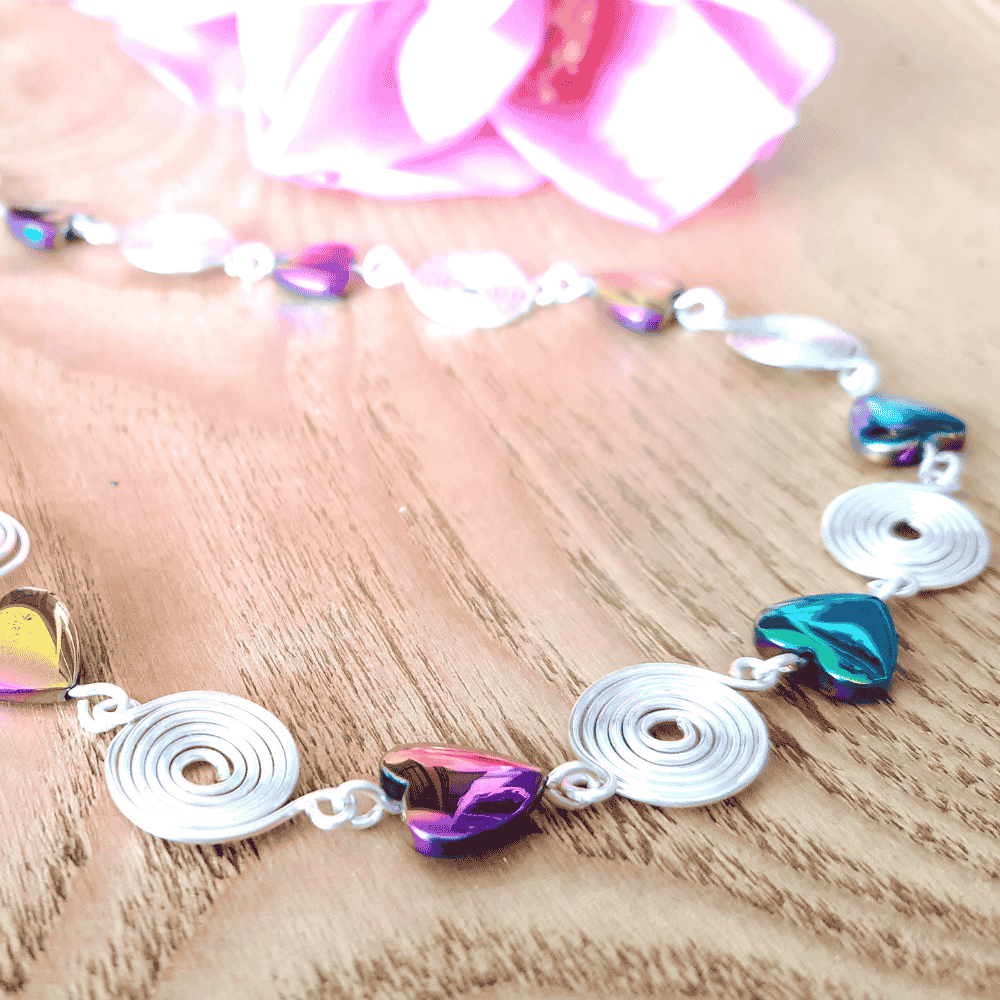 Necklace with colorful heart-shaped beads on a wooden surface